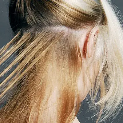 Hand tied weft hair extensions lifted to show the rows underneath