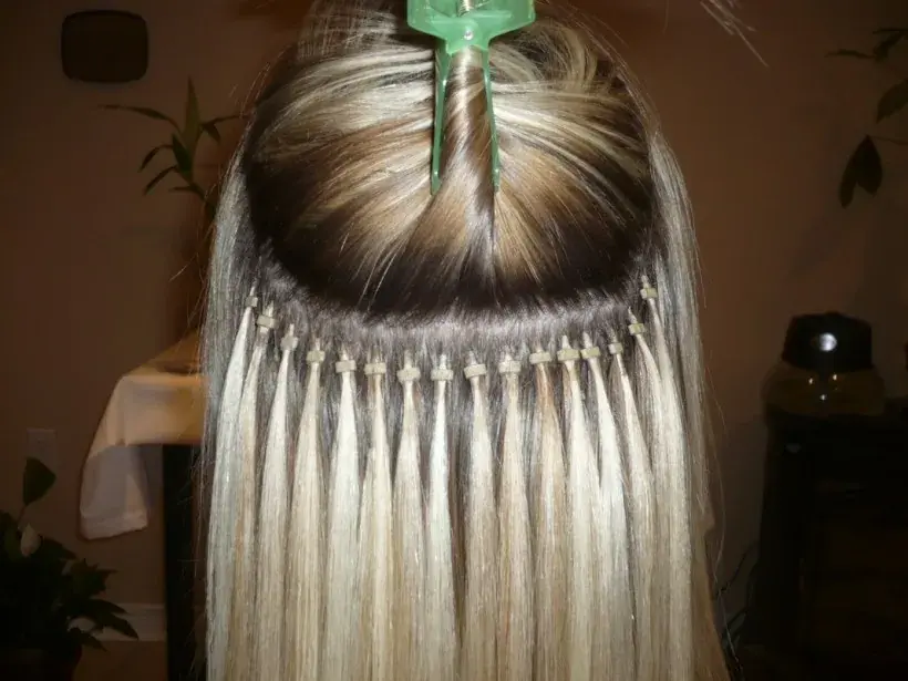 Micro bead hair extensions clamped at the root, with the top section clipped up